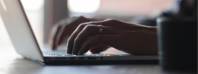 hands typing on laptop