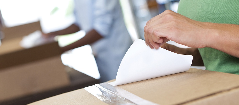 woman removing label from box representing product returns