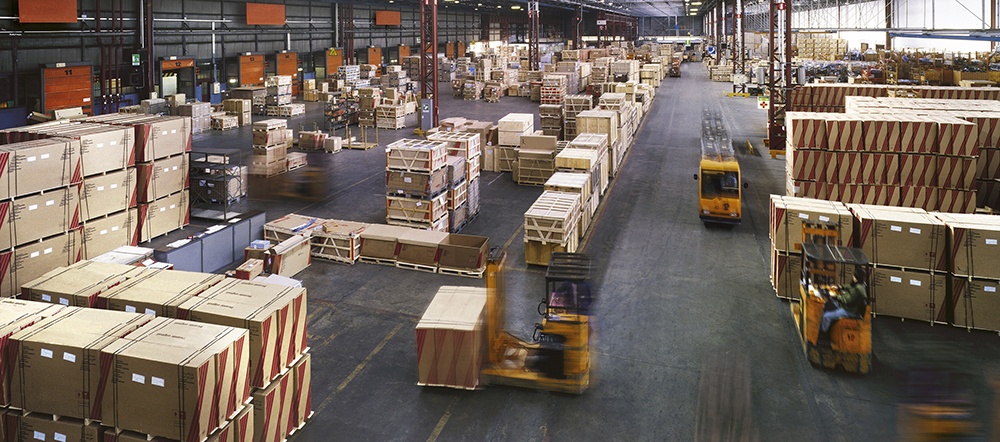 aerial view of a warehouse showing boxes and forklifts representing warehouse management system